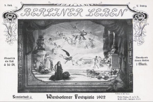 Schwarzes und weißes Foto einer Bühne mit der Aufschrift "Wiesbadener Festspiele 1902" und Darstellern in traditioneller deutscher Kleidung sowie einem applaudierenden Publikum im Hintergrund.