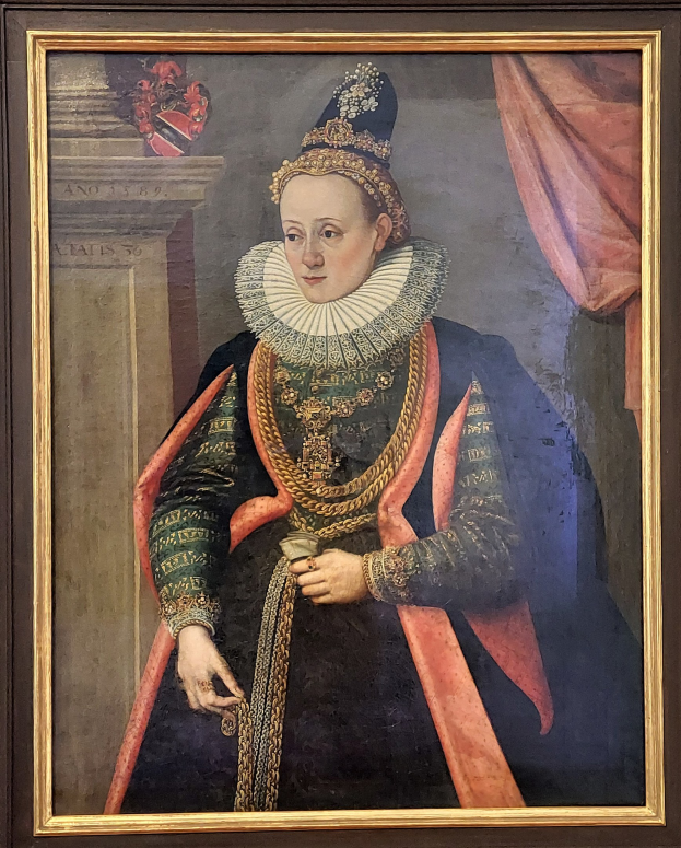 Porträt der Queen Elizabeth I. von England in königlicher Kleidung mit Krone und Tiara, das Haar zu einem Knoten gebunden, mit einem würdevollen Gesichtsausdruck zur Seite blickend, in einem Rahmen an der Wand gehängt.