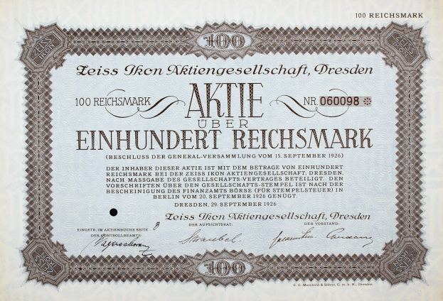 Alter deutscher Aktienchein für 100 Reichmark mit schwarzem Rand und deutschem Text.