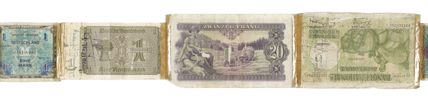 Alte deutsche Banknoten in verschiedenen Nennwerten auf einem alten Buch gestapelt.