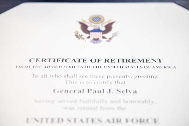 Rahmenurkunde für den Ruhestand von der United States Air Force mit blauem Rand, die ein Schild-Logo mit einem zentralen Stern, einem Lorbeerkranz und einer schwarzen 'Ruhestand'-Bannerschrift zeigt.