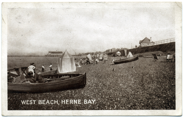 Schwarzes und weißes Foto von Menschen am Weststrand, Herne Bay, mit Booten im Vordergrund, H├Ąusern und einem Zaun im Hintergrund und Text unten.